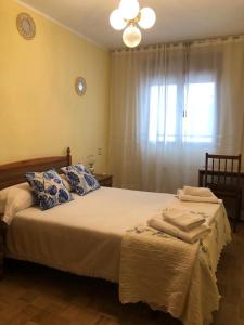 - une chambre avec un lit doté d'oreillers et d'une fenêtre dans l'établissement Apartamento Casa Belén Arriondas, à Arriondas