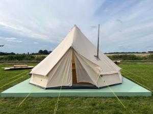 Boyce Fen Farm Retreat Glamping & Fishery في ويزبيتش: خيمة الجرس جالسة في حقل من العشب