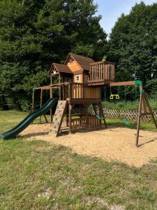 a playground with a tree house and a slide at Osada Gęsin in Zabór