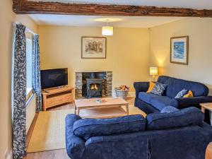 sala de estar con sofás azules y chimenea en Saul Hill, en Lake District National Park