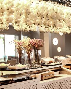 une table avec des vases de fleurs au-dessus dans l'établissement Marathon Beach Resort, à Nea Makri