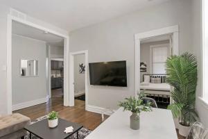 a white living room with a couch and a tv at City Charm 2BR Apartment - Clark 4 in Chicago