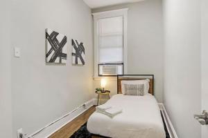 um pequeno quarto com uma cama e uma janela em City Charm 2BR Apartment - Clark 4 em Chicago