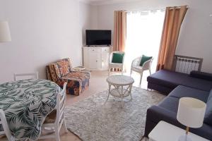 a living room with a blue couch and chairs at Casa de Praia da Zezinha in Costa da Caparica