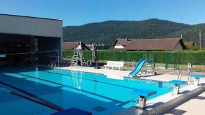 a swimming pool with a slide and a playground at La Clémentine in Vagney
