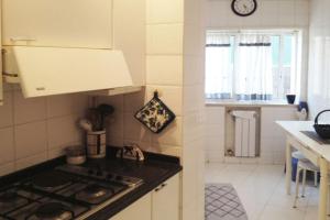 a kitchen with a stove and a counter top at Casa de Praia da Zezinha in Costa da Caparica +9 photos