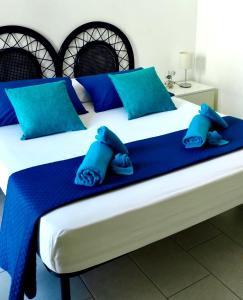1 Schlafzimmer mit 2 Betten und blauen Kissen in der Unterkunft DGS APARTHOTEL in Trapani
