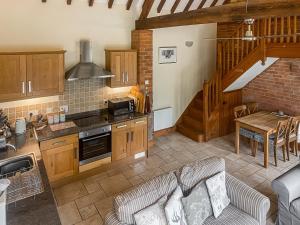 a kitchen and living room with a couch and a table at The Old Carthouse in Abbots Bromley