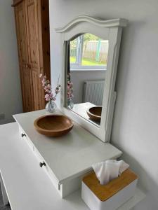 a bathroom with a wooden sink and a mirror at Cosy bungalow with views, walks, garden & parking. in Worcester