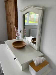 a bathroom with a wooden sink and a mirror at Cosy bungalow with views, walks, garden & parking. in Worcester