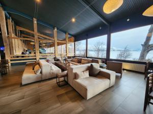 a living room with couches and tables and large windows at Hotel Lago Grey in Torres del Paine