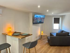 ein Wohnzimmer mit einem Sofa und einem Tisch in der Unterkunft Studio Neuf CentreVille Climatisé #14 in Toulon