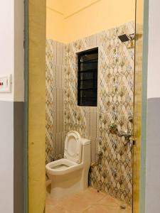 a bathroom with a toilet in a room at Raga Homestay 2.0- Urban Comfort in Guwahati