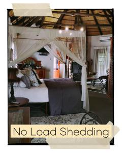 ein Schlafzimmer mit einem Bett mit Baldachin ohne Ummantelung in der Unterkunft Cranberry Cottage in Ladybrand