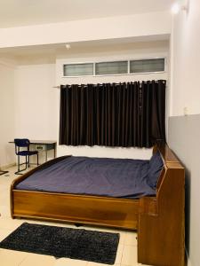 a bedroom with a large bed with a window at Raga Homestay 2.0- Urban Comfort in Guwahati
