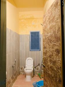 a bathroom with a toilet and a window at Raga Homestay 2.0- Urban Comfort in Guwahati