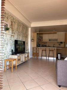een woonkamer met een tv en een keuken bij Três palmeiras with pool in Portimão