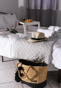 a hat and a basket on a bed with a table at Katerina Family Apartments in Moírai