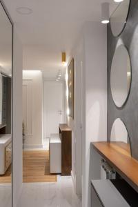 a white bathroom with a sink and a mirror at Golden Apartment With King Bed in Sarajevo