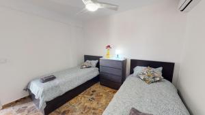 ein Zimmer mit 2 Betten und einer Kommode darin in der Unterkunft Casa de Lago - A Murcia Holiday Rentals Property in Playa de los Nietos