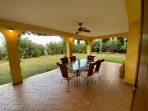 une salle à manger avec une table et des chaises sur une terrasse dans l'établissement Villa Pientime - natura e mare, à Formia