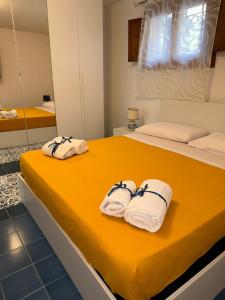 - une chambre avec 2 serviettes sur un lit jaune dans l'établissement Il Viandante sul Mare, à Salerne