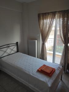 a bedroom with a bed and a large window at Nikos Apartments in Amarynthos