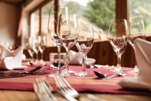 een tafel met wijnglazen en zilverwerk erop bij Hotel Künstleralm in Kaprun