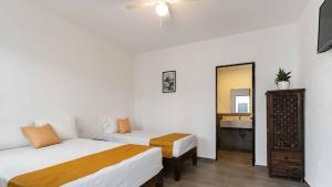 Cette chambre comprend 2 lits et un miroir. dans l'établissement Hotel Posada San Esteban, à San Luis Potosí