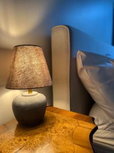 una lámpara sentada en una mesa junto a una cama en NOUBAR, en Cénevières
