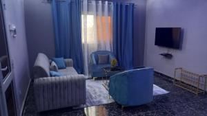 巴馬科的住宿－Appartement Bamako ACI 2000，客厅配有两把椅子和电视