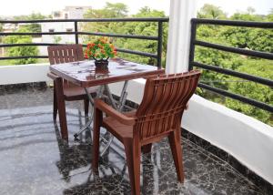 巴馬科的住宿－Appartement Bamako ACI 2000，鲜花阳台的一张桌子和两把椅子