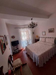 una camera con letto e lampadario a braccio di casa Graziana a Montecatini Val di Cecina