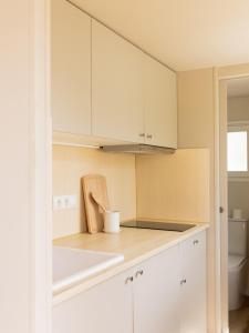 a kitchen with white cabinets and a counter top at wecamp Cadaqués in Cadaqués