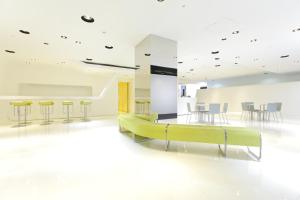 a white room with a green couch and chairs at HOTEL MYSTAYS Ochanomizu Conference Center in Tokyo
