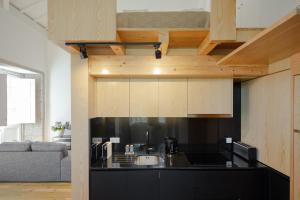 a kitchen with a black counter top and wooden cabinets at Gateway House Studio Apartments in Guimarães