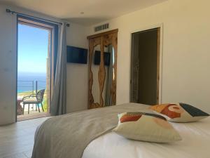 a bedroom with a bed with a view of the ocean at VILLA MACAGNA in Corbara