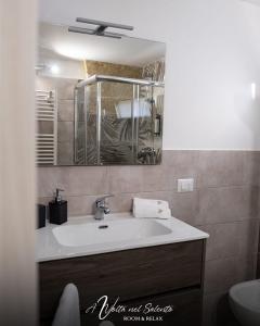 La salle de bains est pourvue d'un lavabo et d'un miroir. dans l'établissement AvVolta nel Salento - Room & Relax, à Torchiarolo