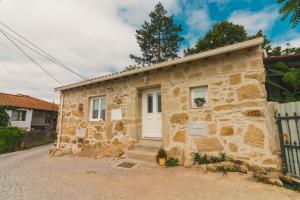 une maison en pierre avec une porte blanche dans l'établissement CHALÉ, à Alijó