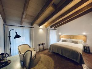 um quarto com uma cama grande e uma cadeira em Hotel Casa Miranda - Adults Only em Maó