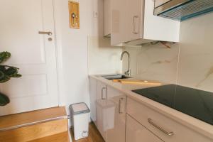 a kitchen with white cabinets and a sink and a trash can at CHALÉ in Alijó