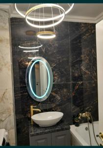 een badkamer met een wastafel en een spiegel aan een muur bij Luxury Home in Oradea