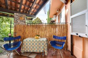a patio with a table and chairs and a fence at Home Charlene in Albenga