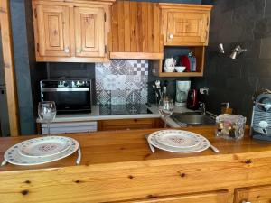 eine Küchentheke mit zwei Tellern und Weingläsern darauf in der Unterkunft Appartement Les Gets, 3 pièces, 8 personnes - FR-1-623-72 in Les Gets