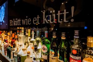 un montón de botellas de alcohol en un bar en Motel One Köln-Mediapark en Colonia