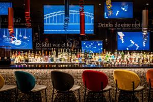 a bar with colorful chairs in front of a bar at Motel One Köln-Mediapark in Cologne