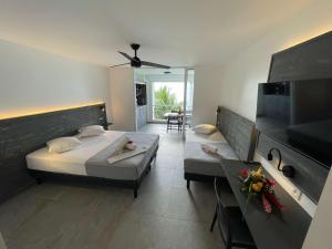 a hotel room with a bed and a living room at Karaibes Residence in Le Gosier