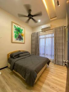 - une chambre avec un lit et un ventilateur de plafond dans l'établissement MURNI INN PERIGI, à Yan