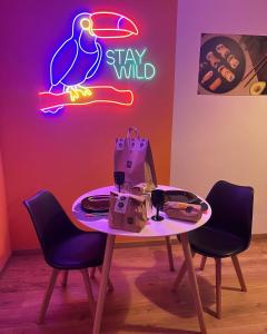 ein Tisch mit Stühlen und ein Schild, auf dem steht: in der Unterkunft Suite Maison Tropical - Luxury Apartment in Bari in Bari