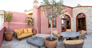 a patio with a table and chairs and a building at Luminous Luxury Apartment in Chania